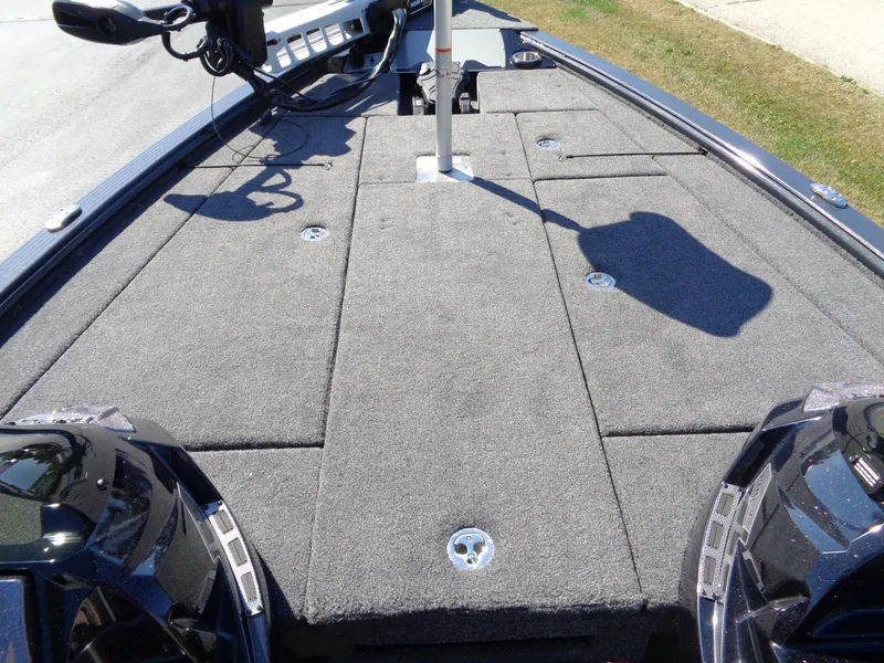 Slide: The Image of 2025 Lund 1875 Pro-V Bass XS boat deck with carpeted surface and storage compartments. - 23