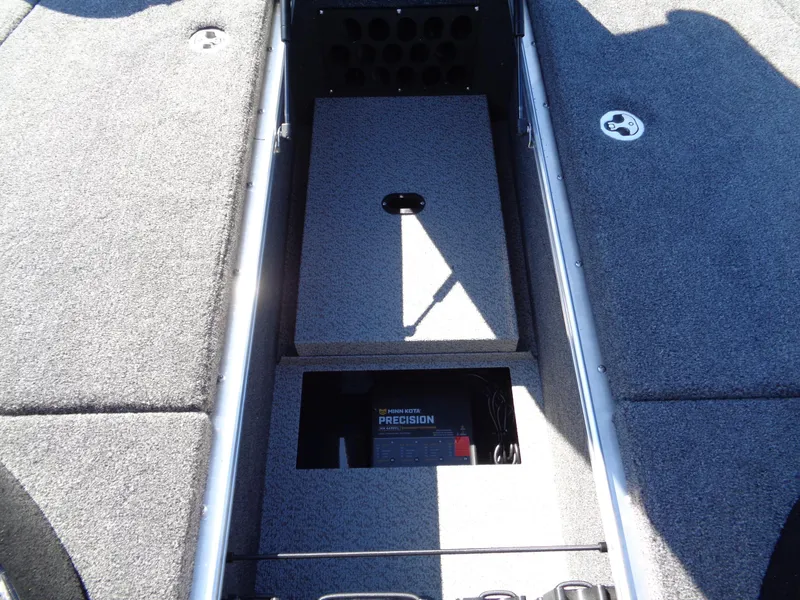 Slide: The Image of 2025 Lund 1875 Pro-V Bass XS boat interior with storage compartment and battery. - 24