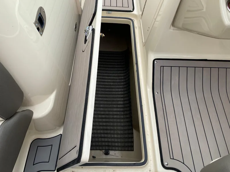 Slide: The Image of 2014 Yamaha Boats 242 Limited S storage compartment with open hatch and non-slip flooring. - 13