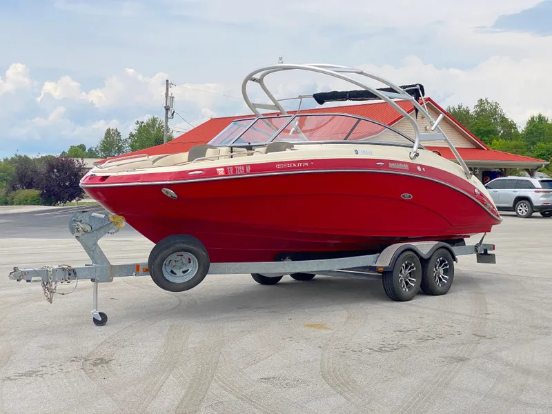 Slide: The Image of 2014 Yamaha Boats 242 Limited S, red, on trailer, parked outdoors. - 2