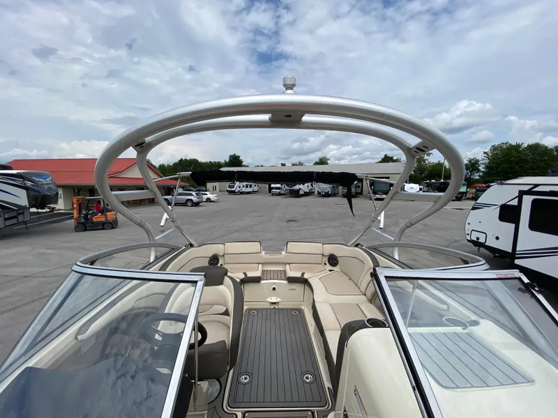 Slide: The Image of 2014 Yamaha Boats 242 Limited S interior with open deck and seating, parked outdoors. - 30