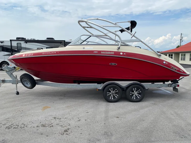 Slide: The Image of 2014 Yamaha Boats 242 Limited S, red, on trailer, parked outdoors. - 43