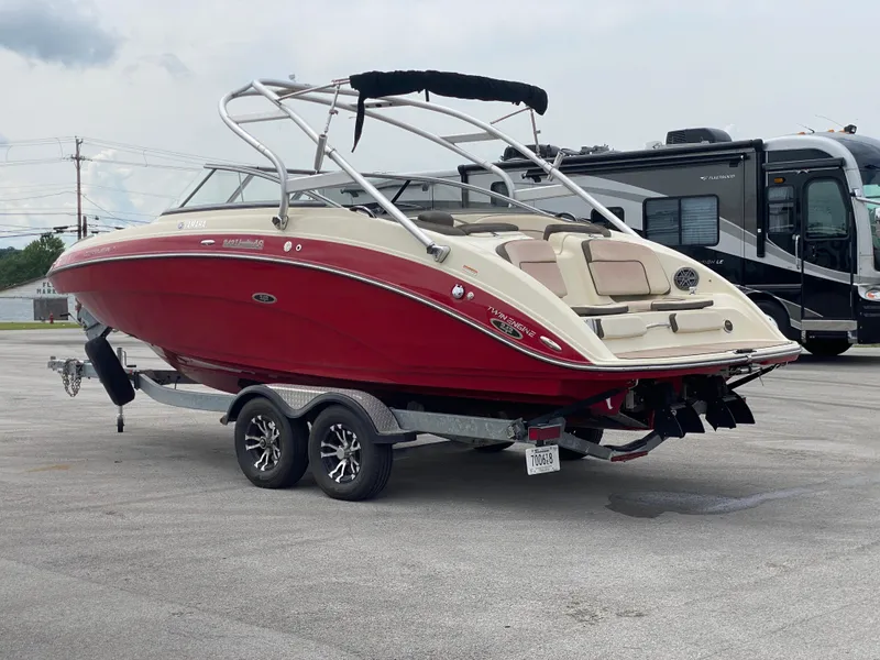 Slide: The Image of 2014 Yamaha Boats 242 Limited S in red, parked on a trailer. - 44