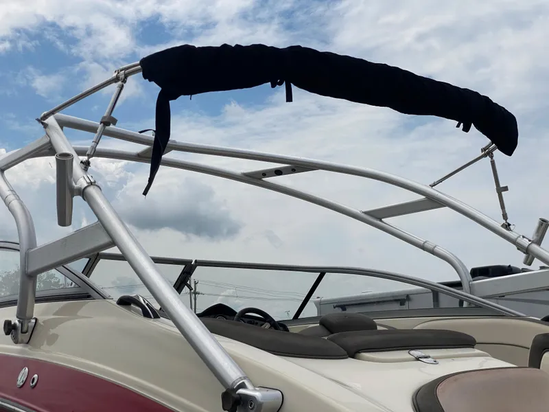 Slide: The Image of 2014 Yamaha Boats 242 Limited S with bimini top against cloudy sky. - 46