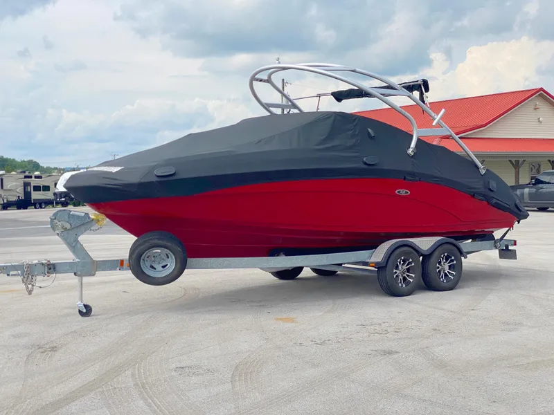 Slide: The Image of 2014 Yamaha Boats 242 Limited S, red, covered, on trailer, parked outdoors. - 6