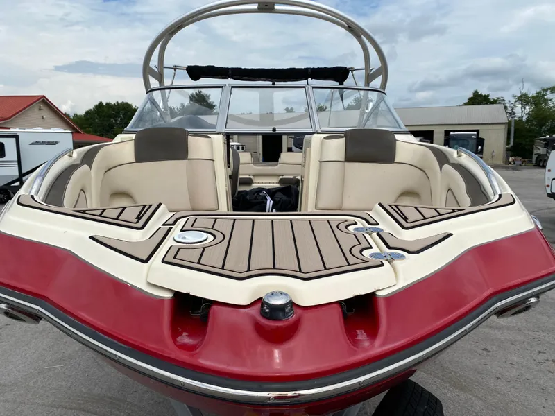 Slide: The Image of 2014 Yamaha Boats 242 Limited S, red and beige interior, docked outdoors. - 8