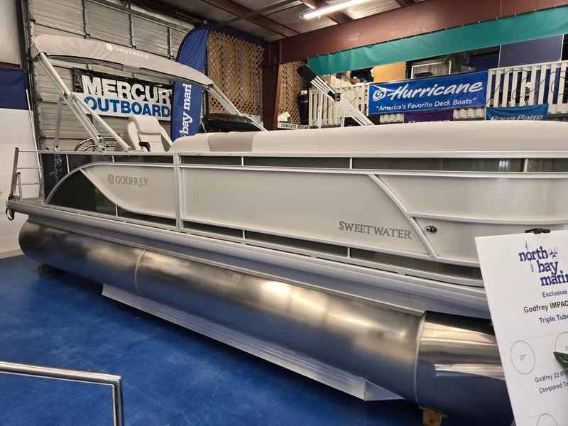 Slide: The Image of 2025 Godfrey Sweetwater 2086 C pontoon boat in showroom, featuring Mercury outboard. - 5