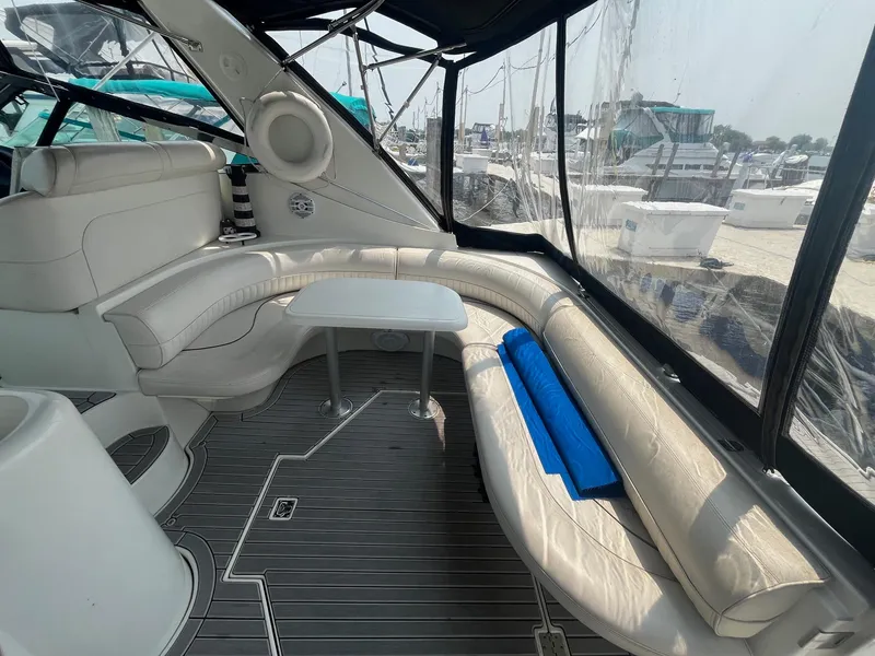 Slide: The Image of 2001 Cruisers Yachts 3870 Express interior with white seating and table, docked at marina. - 20