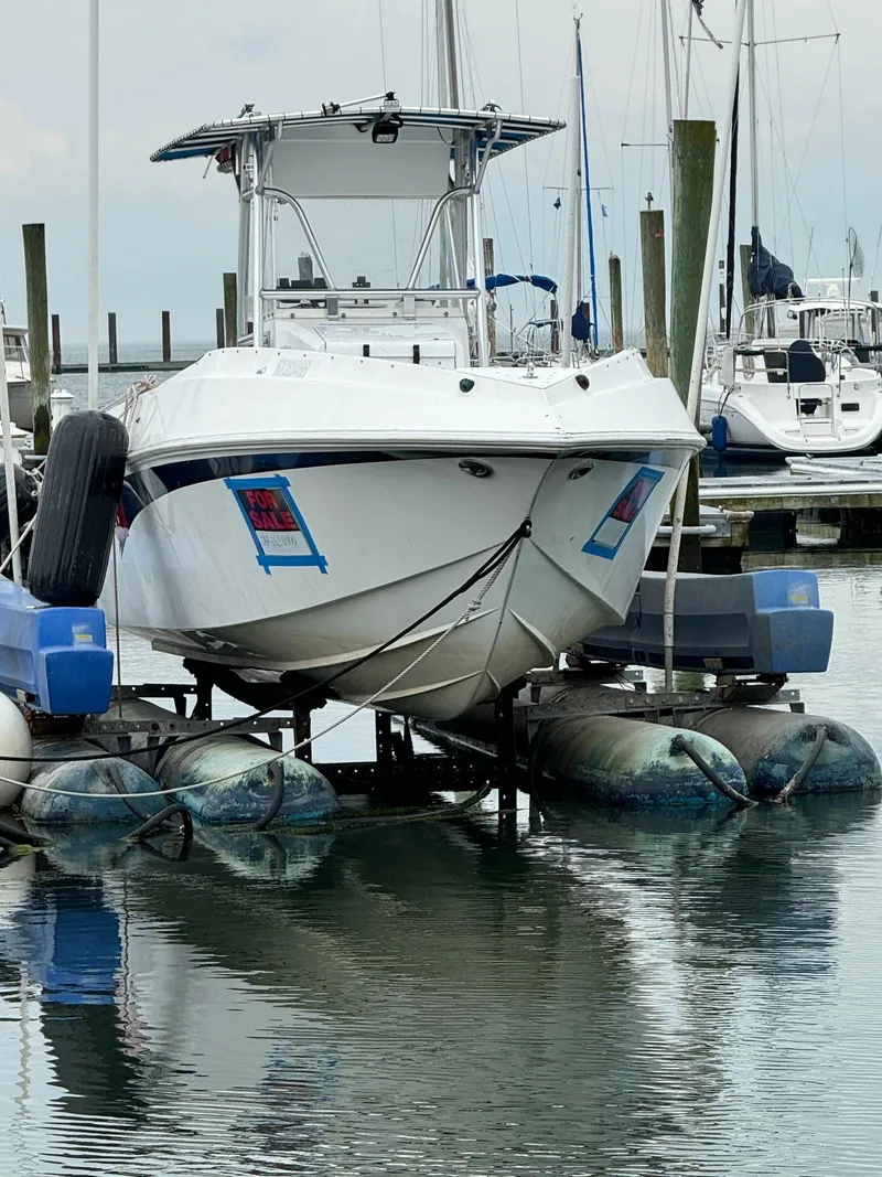 Slide: The Image of Boat for sale at marina, Fountain CC model, 2000, on lift with water reflection. - 3