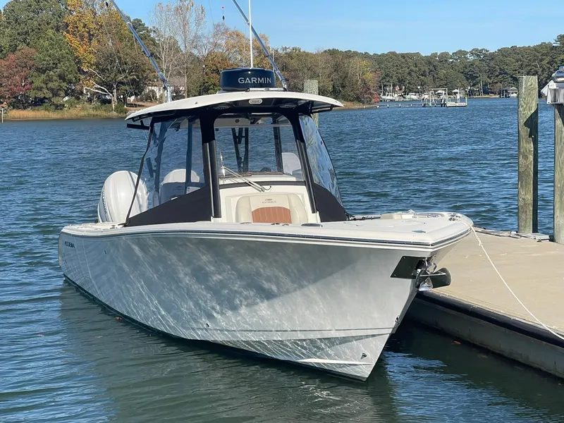 Slide: The Image of 2023 Cobia 320 CC boat docked on a sunny day. - 1
