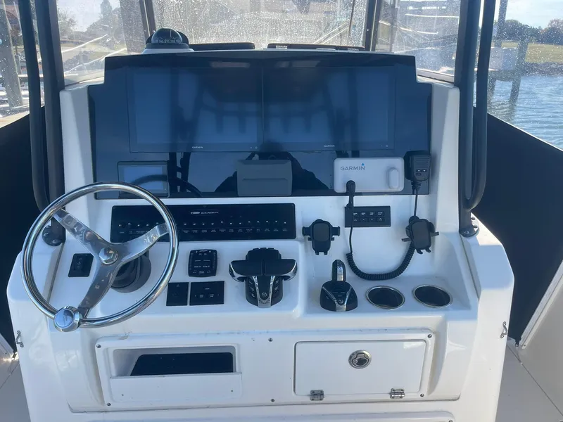 Slide: The Image of 2023 Cobia 320 CC boat dashboard with Garmin navigation system and steering wheel. - 11