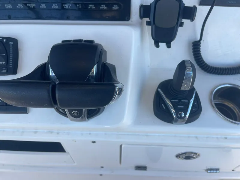 Slide: The Image of Cobia 320 CC 2023 boat controls and dashboard with throttle and joystick. - 12