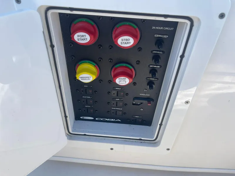 Slide: The Image of Control panel of 2023 Cobia 320 CC boat with start buttons and switches. - 18