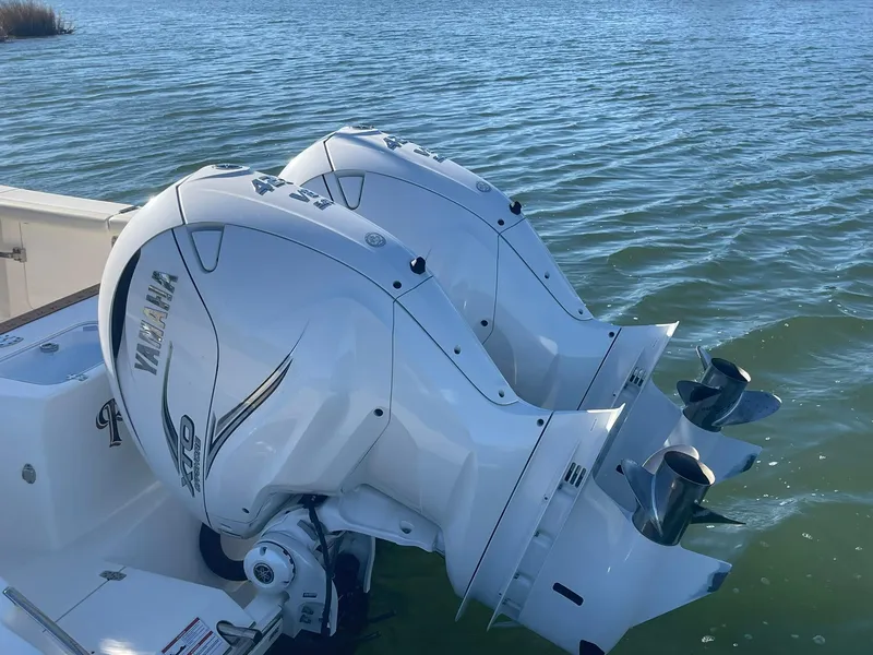 Slide: The Image of 2023 Cobia 320 CC boat with twin Yamaha outboard engines on water. - 4