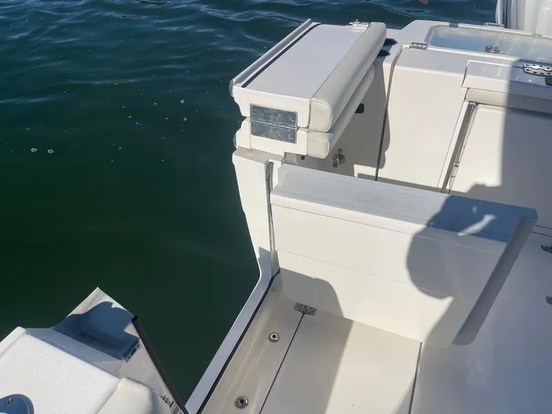Slide: The Image of 2023 Cobia 320 CC boat deck detail with seating, on calm water. - 7