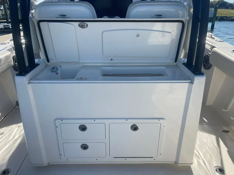 Slide: The Image of 2023 Cobia 320 CC boat interior with storage compartments and sink. - 8