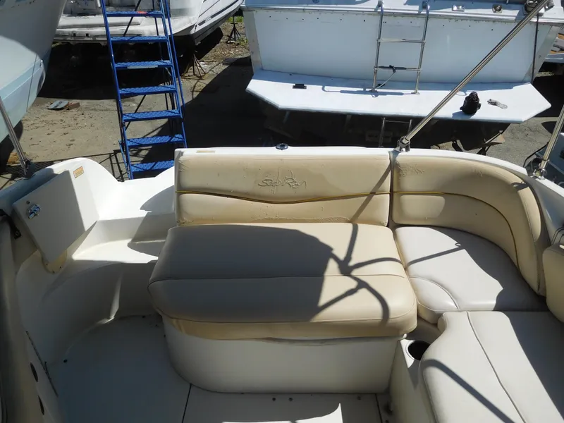 Slide: The Image of 2002 Sea Ray 240 Sundeck boat interior with beige seating and storage. - 5