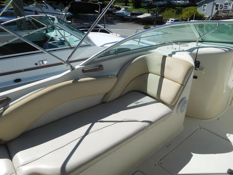 Slide: The Image of 2002 Sea Ray 240 Sundeck boat interior with beige seating and glass windshield. - 7