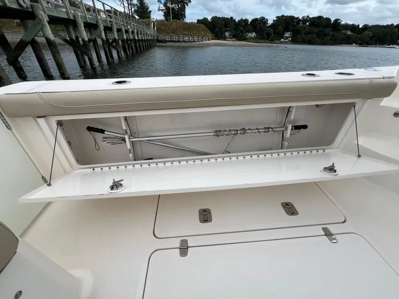 Slide: The Image of 2016 Pursuit OS 385 Offshore boat with open storage compartment by the water. - 14