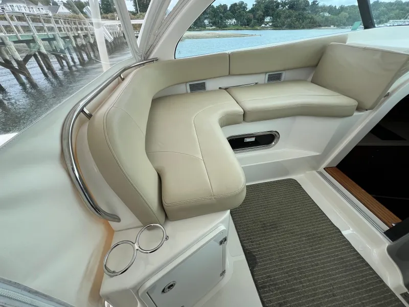 Slide: The Image of 2016 Pursuit OS 385 Offshore boat interior with beige seating and waterfront view. - 32