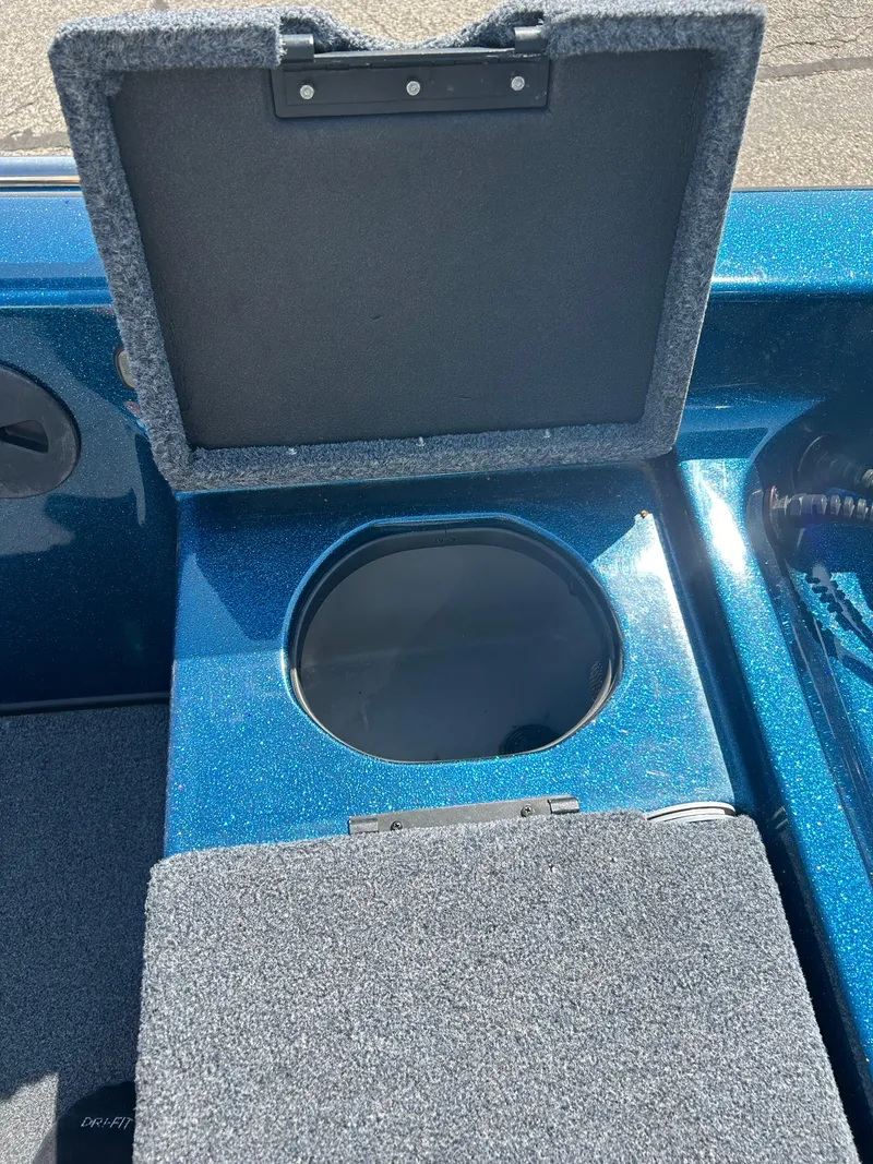 Slide: The Image of Open storage compartment on a 2005 Skeeter WX 1880 boat, featuring blue interior. - 21