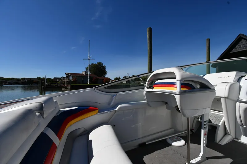 Slide: The Image of 2003 Formula 353 FASTech boat interior with colorful seating, docked under clear blue sky. - 21