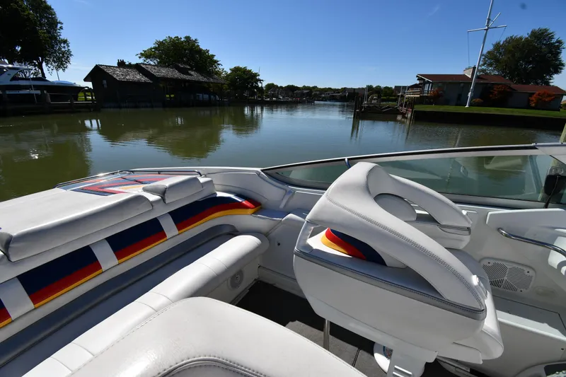 Slide: The Image of 2003 Formula 353 FASTech boat interior with colorful seating by a serene lake. - 23