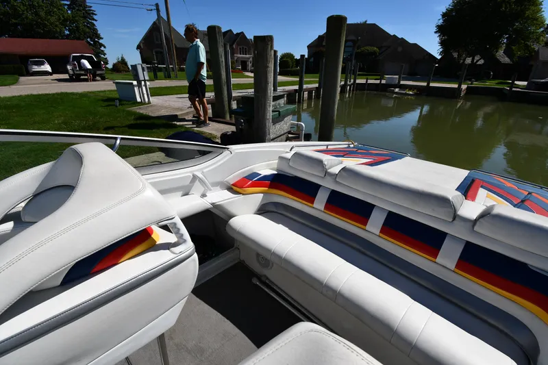 Slide: The Image of 2003 Formula 353 FASTech boat interior with colorful seating at a dockside location. - 24