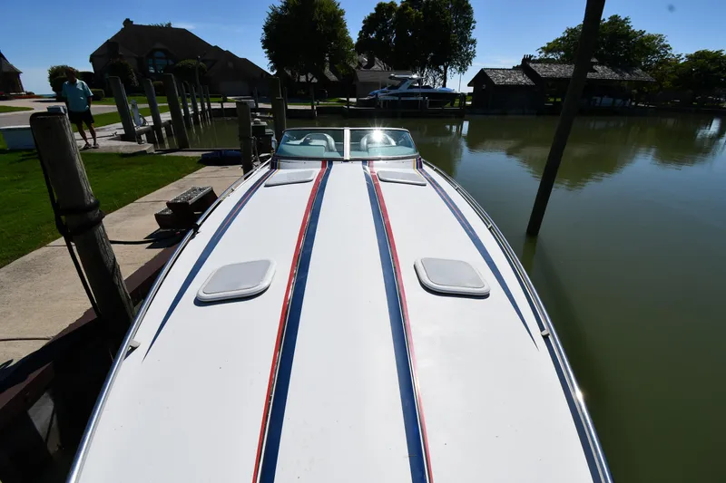 Slide: The Image of 2003 Formula 353 FASTech boat docked by a serene lakeside. - 4