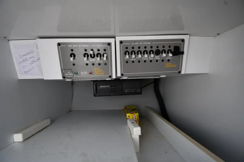 Slide: The Image of Control panel inside 2003 Formula 353 FASTech boat, featuring switches and a Kenwood device. - 43