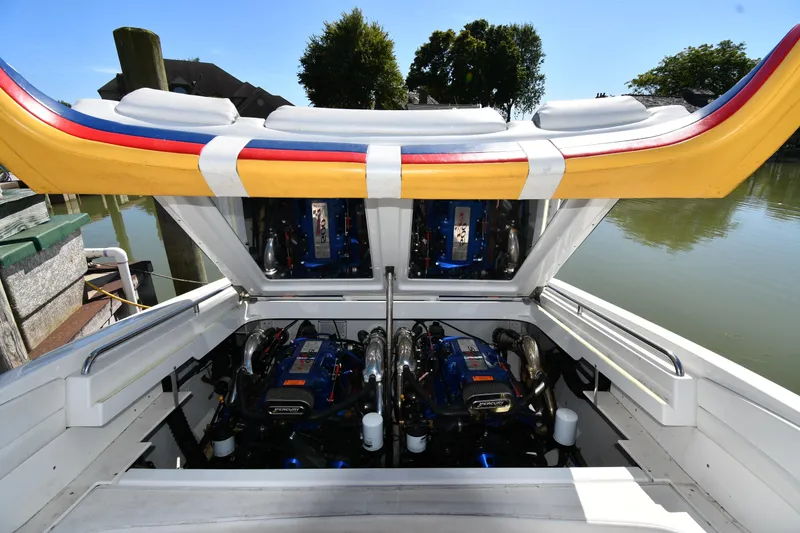 Slide: The Image of 2003 Formula 353 FASTech boat engine compartment with dual engines, open hatch, and colorful upholstery. - 45
