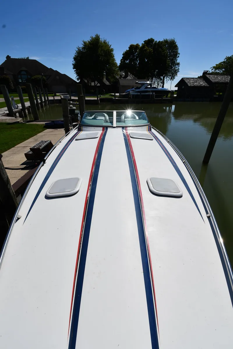 Slide: The Image of 2003 Formula 353 FASTech boat docked, showcasing sleek design and vibrant stripes. - 5