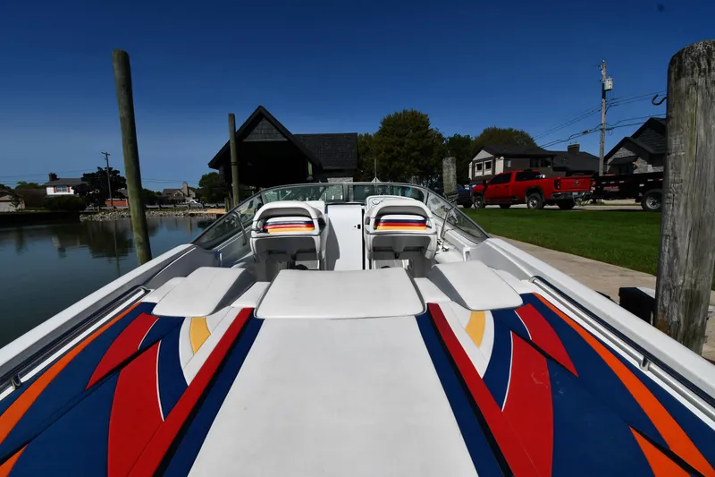 Slide: The Image of 2003 Formula 353 FASTech boat with vibrant graphics docked at a marina. - 6