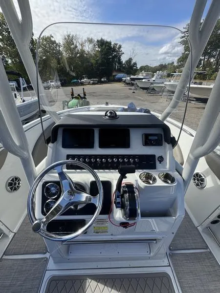 Slide: The Image of 2021 Finseeker 200 CC boat console with steering wheel and controls, docked outdoors. - 25