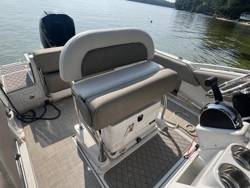 Slide: The Image of 2021 Finseeker 200 CC boat interior with seating and controls on a calm lake. - 26