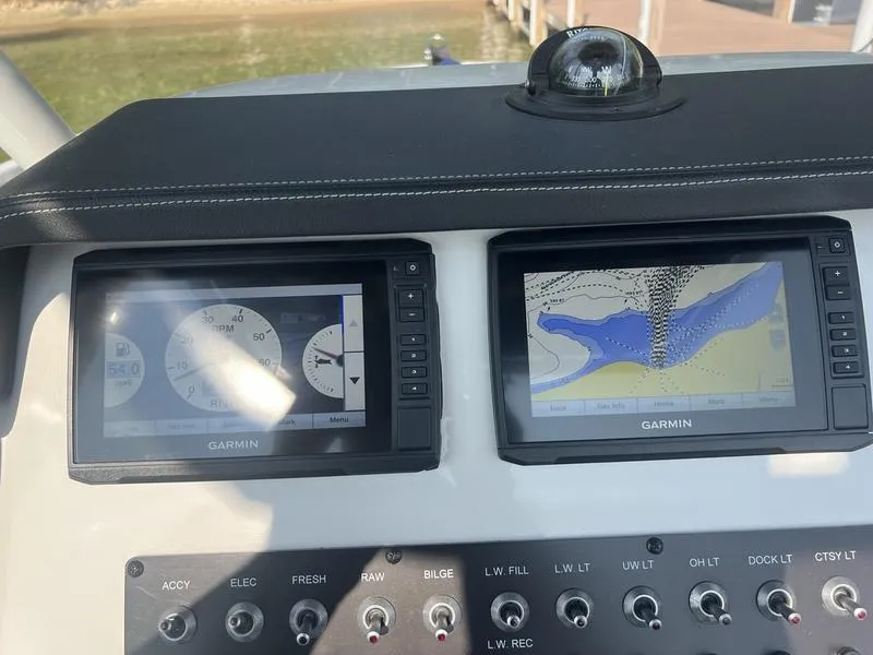 Slide: The Image of Finseeker 200 CC 2021 boat dashboard with Garmin navigation displays and control switches. - 6
