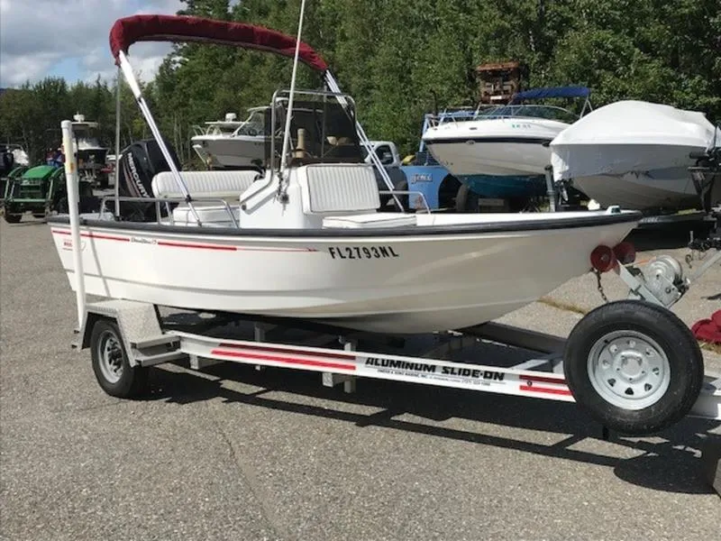 Slide: The Image of 1995 Boston Whaler 150 Dauntless boat on trailer, parked outdoors. - 4