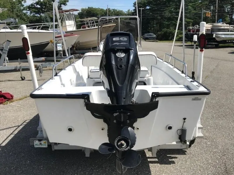 Slide: The Image of 1995 Boston Whaler 150 Dauntless boat with outboard motor, parked on a trailer. - 6