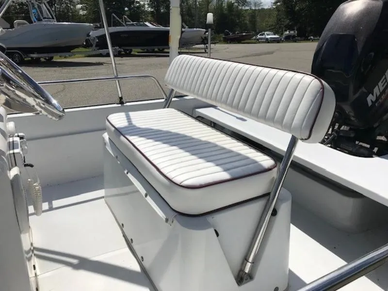 Slide: The Image of 1995 Boston Whaler 150 Dauntless boat interior with white cushioned seating. - 9