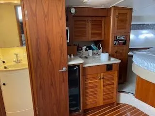 Slide: The Image of Interior of 2000 Pursuit 3400 Express boat with wooden cabinetry and compact amenities. - 13