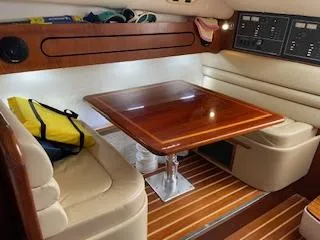 Slide: The Image of Interior of 2000 Pursuit 3400 Express boat with wooden table and cushioned seating. - 18