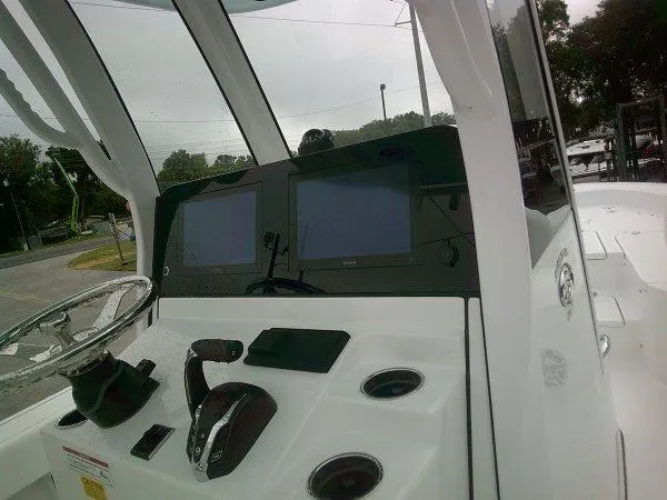 Slide: The Image of 2025 Sportsman 267 Masters boat dashboard with dual screens and steering wheel. - 4