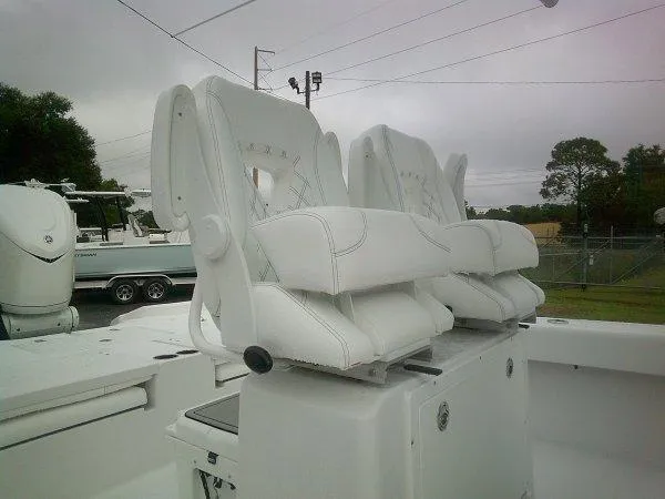 Slide: The Image of 2025 Sportsman 267 Masters boat with white cushioned seats, outdoor setting. - 6