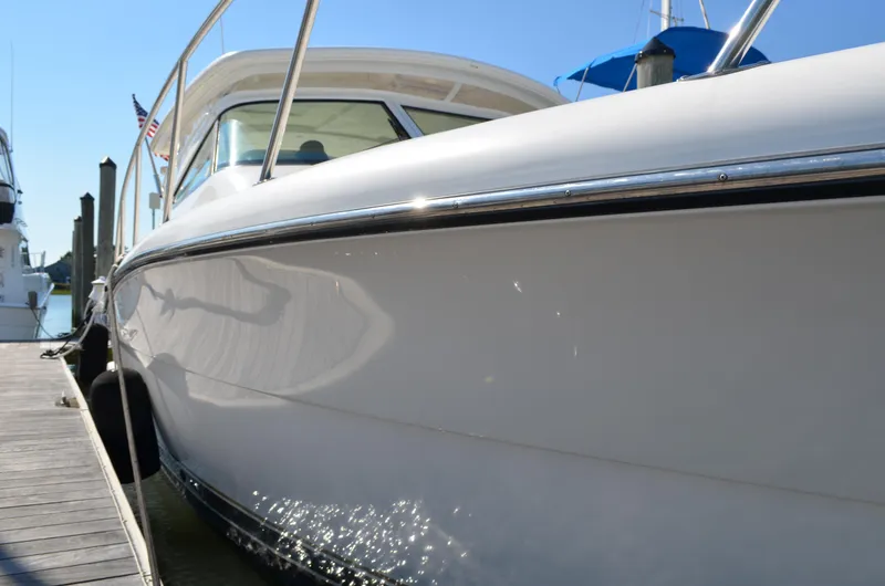 Slide: The Image of 2004 Tiara Yachts 3800 Open docked, showcasing sleek white hull and polished railings. - 12