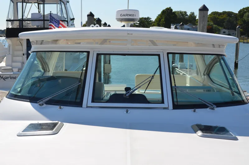 Slide: The Image of 2004 Tiara Yachts 3800 Open at dock, featuring sleek windshield design. - 13