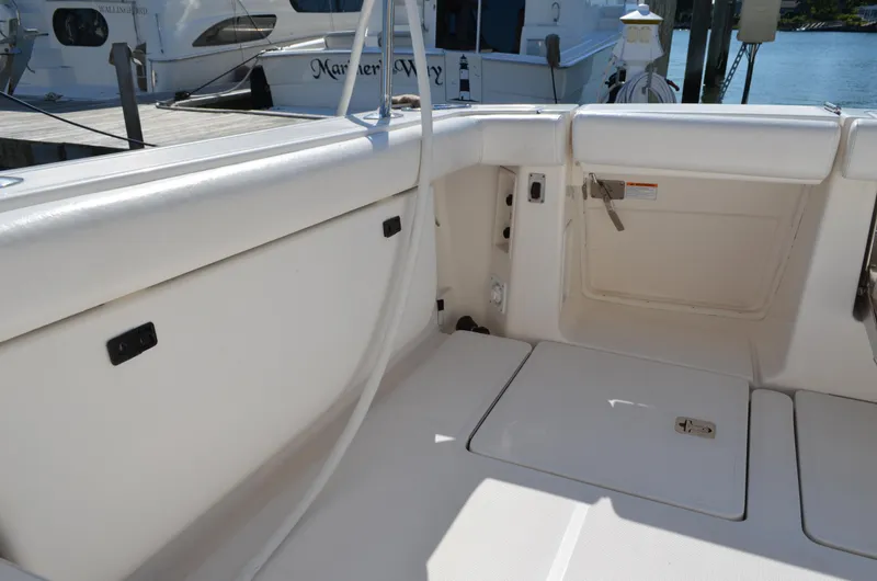 Slide: The Image of 2004 Tiara Yachts 3800 Open boat interior, featuring clean white seating and storage compartments. - 21