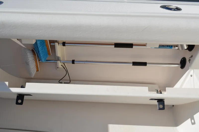 Slide: The Image of Storage compartment on a 2004 Tiara Yachts 3800 Open, holding cleaning brushes and tools. - 23