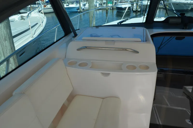 Slide: The Image of 2004 Tiara Yachts 3800 Open interior with seating and cup holders, docked at marina. - 29