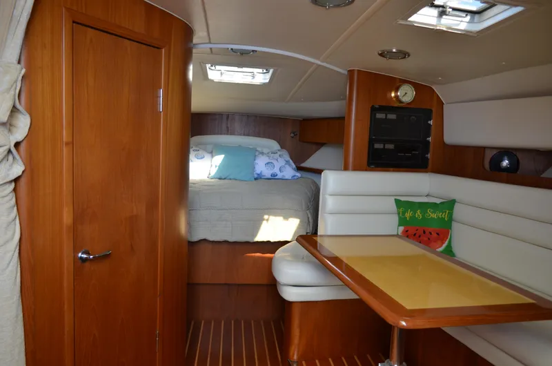 Slide: The Image of Interior of 2004 Tiara Yachts 3800 Open, featuring cozy cabin and dining area. - 42