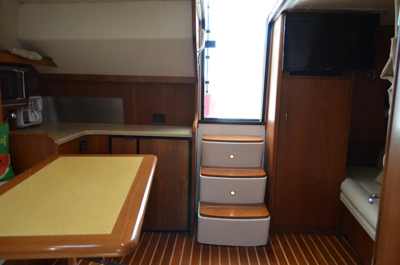 Slide: The Image of Interior of 2004 Tiara Yachts 3800 Open, featuring wood cabinetry and modern amenities. - 49